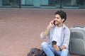 Millennial Guy Talking On Cellphone And Drinking Coffee Outside Of Airport Royalty Free Stock Photo