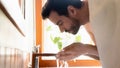 Millennial handsome guy doing morning skincare hygiene routine.