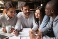 Multiracial young people studying in coffeehouse together