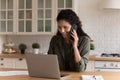 Millennial latina woman expert using laptop phone in remote work