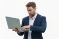 Millennial man in suit working on laptop in studio. Hispanic man checking information on laptop, typing information on