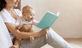 Millennial mom reading book to her baby boy at home Royalty Free Stock Photo