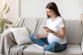 Millennial Pregnant Lady With Smartphone And Credit Card At Home Shopping Online Royalty Free Stock Photo