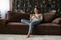 Millennial woman rest on sofa enjoy online dating using phone
