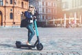 woman rides electric scooter in the city streets. eco friendly transportation
