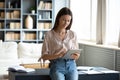 Millennial woman stand browsing internet on pad