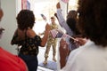 Millennial woman and family welcoming young African American male soldier home, close up