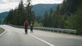 Millennials riding bikes together in mountains landscape. Hipsters cycling road. Royalty Free Stock Photo