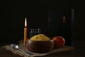 Millet, apple, water, burning candle, Bible and crucifix on wooden table. Great Lent season Royalty Free Stock Photo