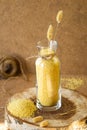 Millet in a glass jar on a wooden stand, next is an ear of wheat