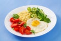 Millet porridge and tomato, cucumber salad and fried eggs. Royalty Free Stock Photo