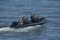 Miltary boat floating on water, armed soldiers of Special Forces aboard Royalty Free Stock Photo