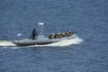 Miltary boat floating on the water, soldiers of Seaborne Special Forces aboard armed with machine guns