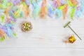 Milticolor bird feathers and Easter eggs. Easter concept. Top view, close up, flat lay on white wooden background Royalty Free Stock Photo