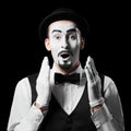 Mime artist expresses surprise emotion. Isolated on black background. Royalty Free Stock Photo