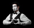 Mime artist showing love sign with hands. Isolated on black. Valentine`s day concept.