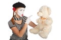 Mime comedian talking with teddy bear