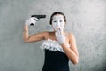 Mime female artist performing with gun