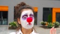 Mime girl dancing. Beautiful clown woman with red nose is having fun outdoor