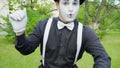 Comic mime is crooking on camera in the park