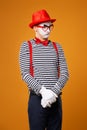 Mime man looking at side in vest and red hat Isolated on orange background Royalty Free Stock Photo