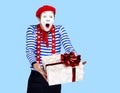 Mime with present.Emotional funny actor wearing Royalty Free Stock Photo