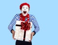 Mime with present.Emotional funny actor wearing