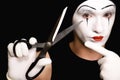 Mime with scissors on black background Royalty Free Stock Photo