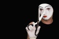 Mime with scissors on black background Royalty Free Stock Photo