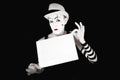 Mime in striped gloves holding white blank