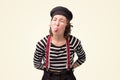 Mime young female shows tongue, has fun.