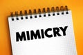 Mimicry is an evolved resemblance between an organism and another object, text concept on notepad Royalty Free Stock Photo