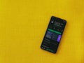 Mimo - Learning coding app play store page on the display of a black mobile smartphone on a yellow fabric background
