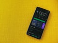 Mimo - Learning coding app play store page on the display of a black mobile smartphone on a yellow fabric background