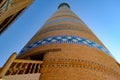 Minaret Islam Khoja in Khiva, Uzbekistan. Old minaret with a stairway inside on the sky background in sunset.