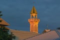 Minaret of the mosque in the orange rays of sunset against the dark sky Royalty Free Stock Photo