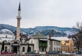 A minaret rises over buildings across the river from the Old Town neighborhood of Sarajevo, Royalty Free Stock Photo