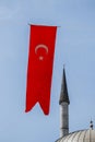 Minaret and Turkish national flag with white star and moon Royalty Free Stock Photo