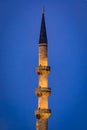 Minaret the Yeni Cami or New Mosque illuminated at sunrise in Istanbul, Turkey Royalty Free Stock Photo