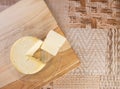 Minas cheese on a polished board arranged on a table with beige tablecloth and gray fudo, Top view