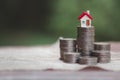 Minature houses resting on coin stacks, concept for property ladder, mortgage and real estate investment