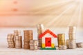 Minature houses resting on pound coin stacks