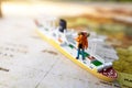 Minature people: traveling with a backpack standing on vintage world map and ship, Travel and vacation concept