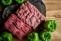 Mince and peppers. Ingredients for stuffed peppers. Two types of minceand and bell pepper.On a wooden background. Royalty Free Stock Photo