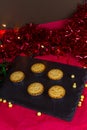 Mince pies in a slate mat at Christmas, portrait with tinsel Royalty Free Stock Photo