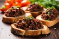 minced black olive tapenade on small bruschetta pieces