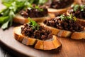 minced black olive tapenade on small bruschetta pieces