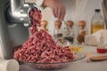 Minced meat comes out of a meat grinder against the background of glassware of a chemical laboratory.