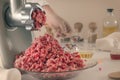 Minced meat comes out of a meat grinder against the background of glassware of a chemical laboratory.