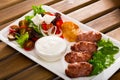 Minced meat kebapcheta served with salad of greens and brynza